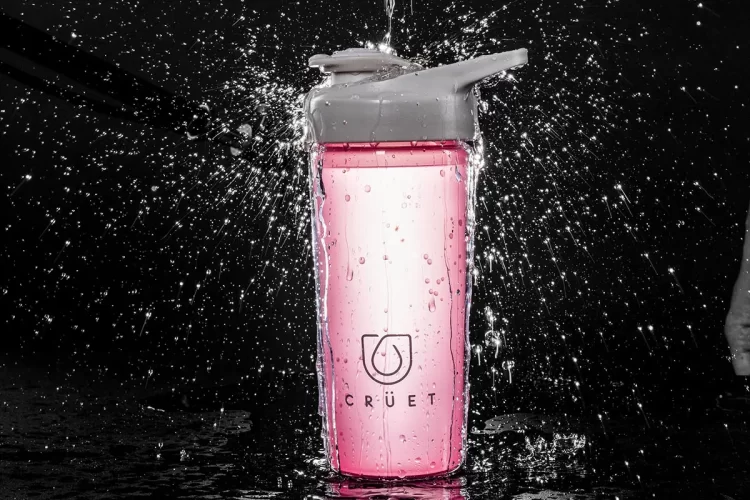 A pink water bottle with water splashing out of it, featuring the best promotions.