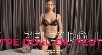 A woman in lingerie is sitting on a bed with the words zelix doll oil test.