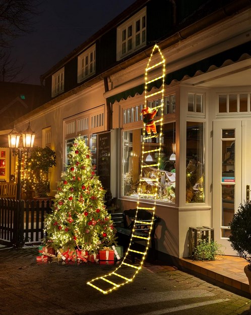 A christmas ladder with lights in front of a store.