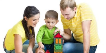 A family is playing with colorful blocks on the floor.