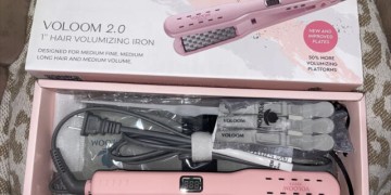 A pink hair straightener in a box.