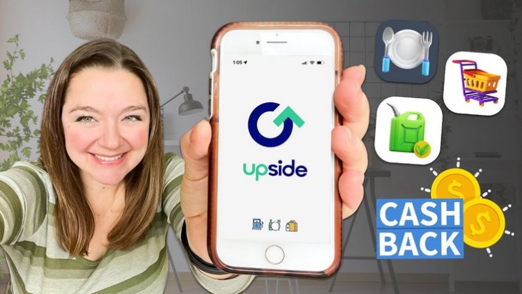 A woman is holding up a phone with the words upside cash back.