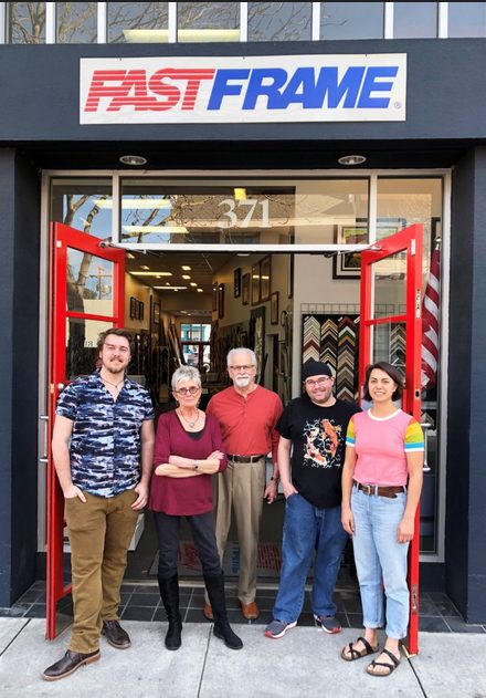 A group of people standing in front of a fast frame store.