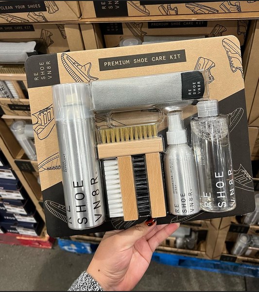 A person holding a shoe care kit in a store.